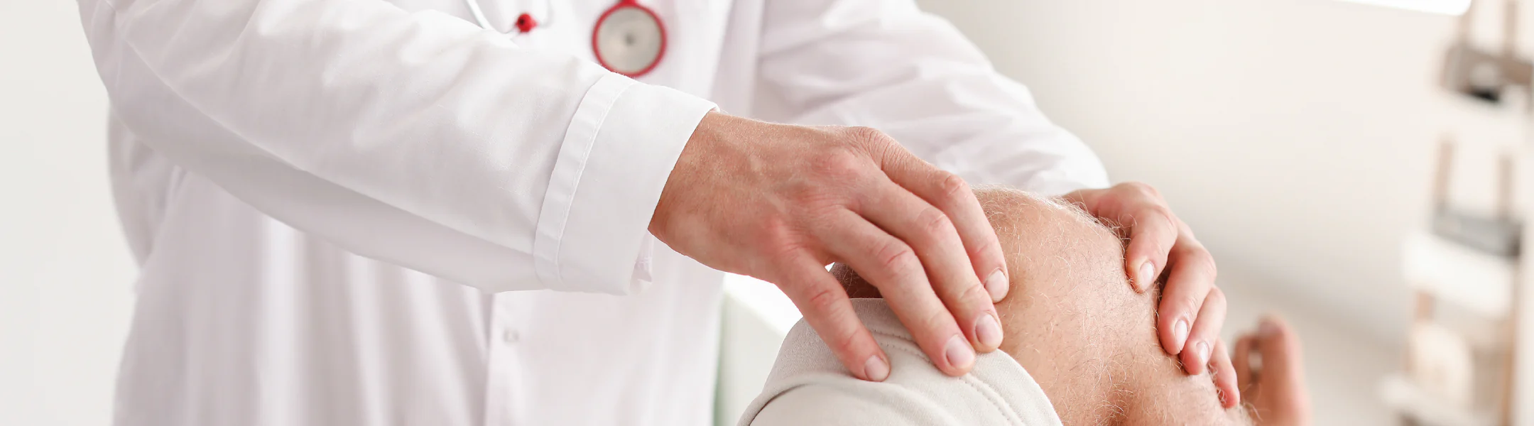 Médecin en blouse blanche examinant le genou d’un patient allongé, dans un contexte de douleur articulaire ou d’injection intra-articulaire.